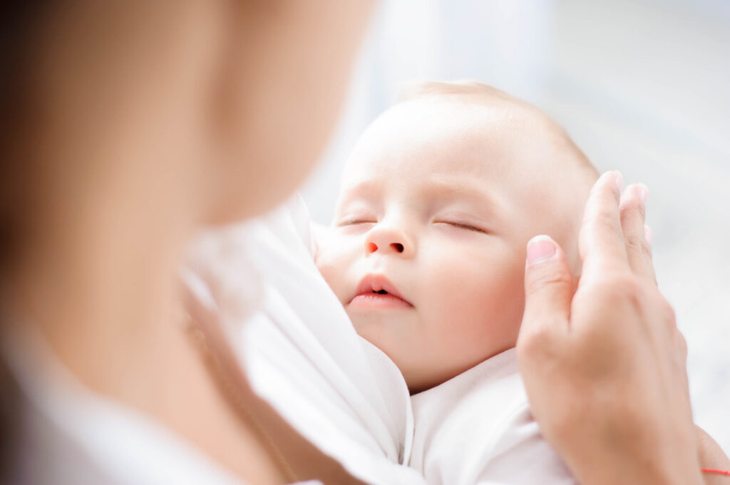 Woman cuddling a sleeping baby